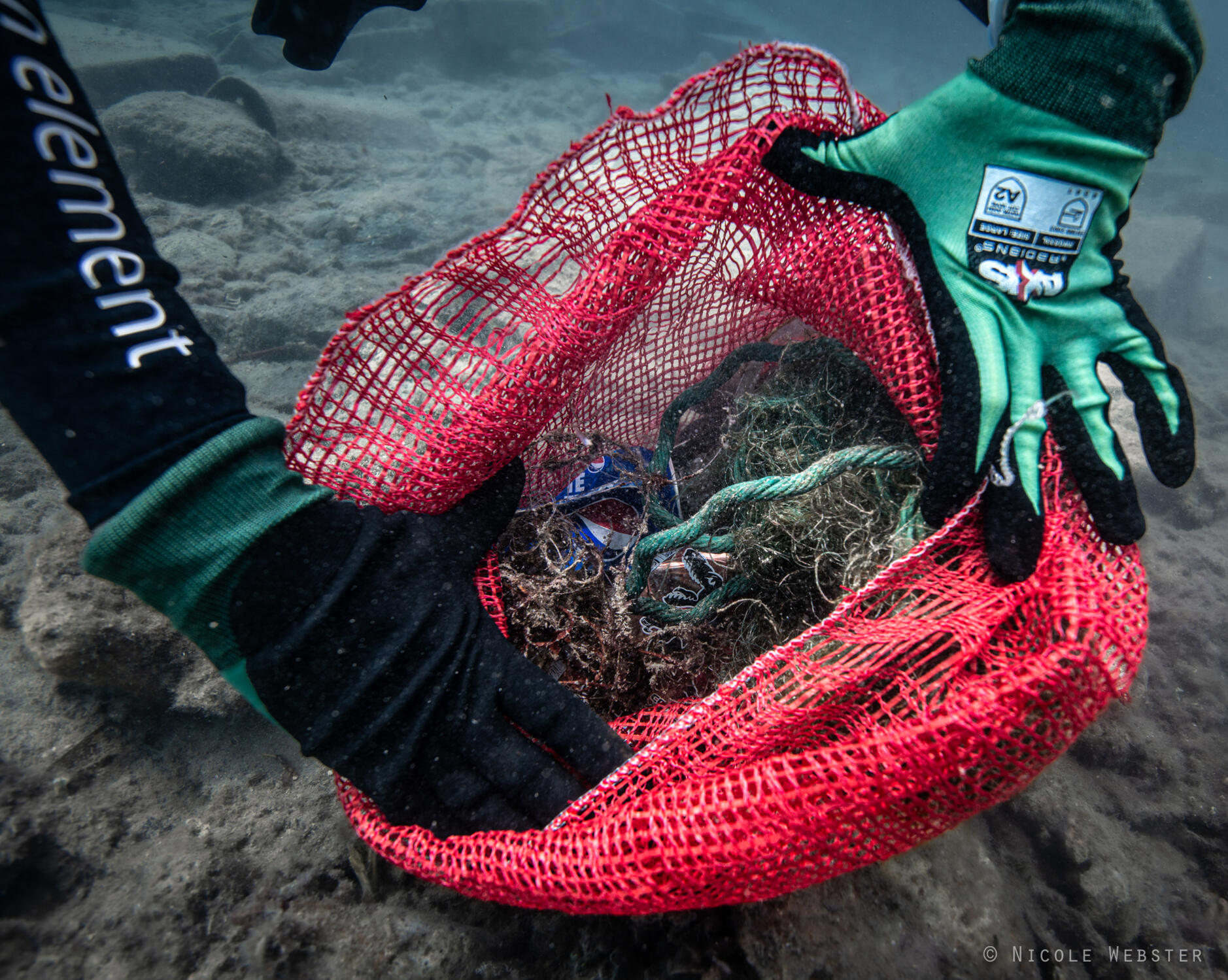 Caught in the Chaos: A diver shows a bundle of discarded fishing line and rope, highlighting the devastating impact of marine debris on ocean life and the urgent need for responsible fishing practices to protect our waterways.