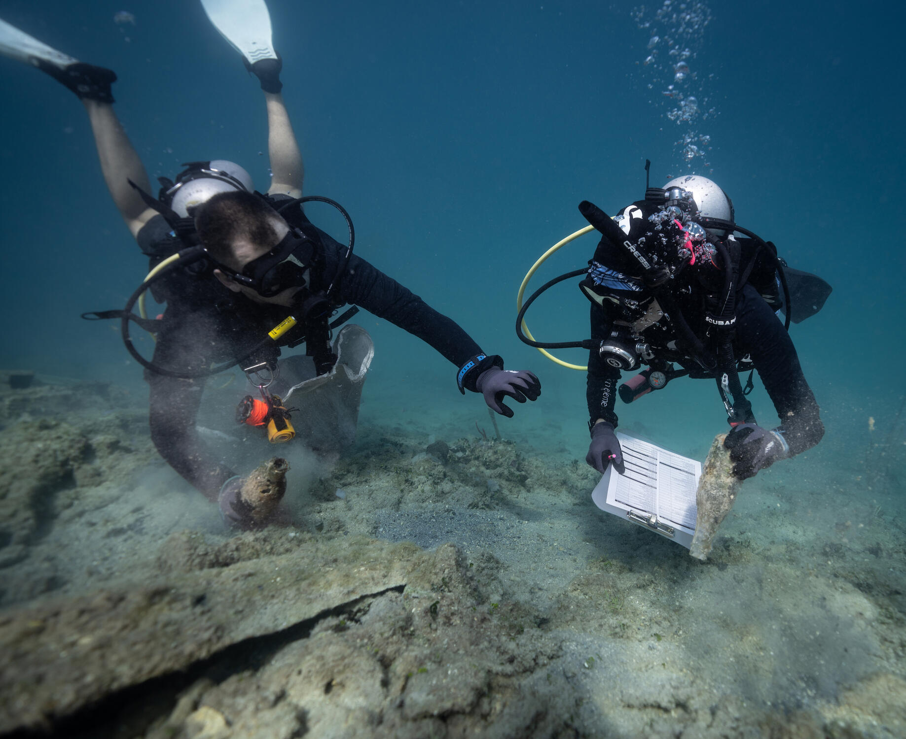 Collective Effort: Working as a team, divers carefully remove plastic waste, prioritizing the safety of marine life that calls this area home.
